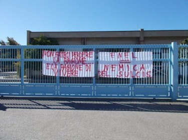 Banners on the gates of the Carbosulcis mine. Photo via the "Sulcis in Fundo" Facebook group.